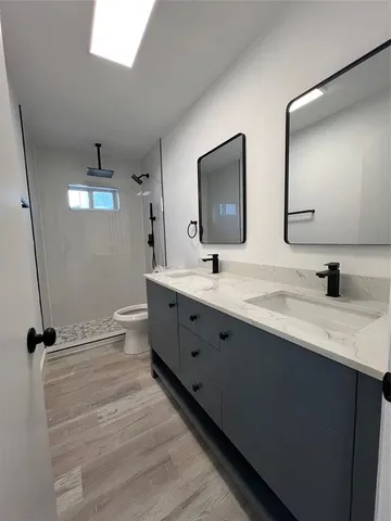 a bathroom with double vanity and a mirror