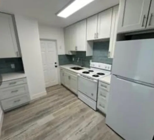 a kitchen with cabinets appliances and a window