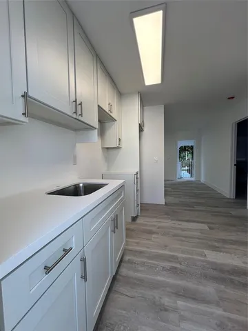 a kitchen with granite countertop white cabinets and sink