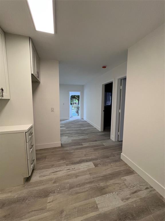 2115 North Ocean Boulevard, Unit 11 Fort Lauderdale, FL 33305 - Photo 5 of 17 a view of an empty room with wooden floor and a window