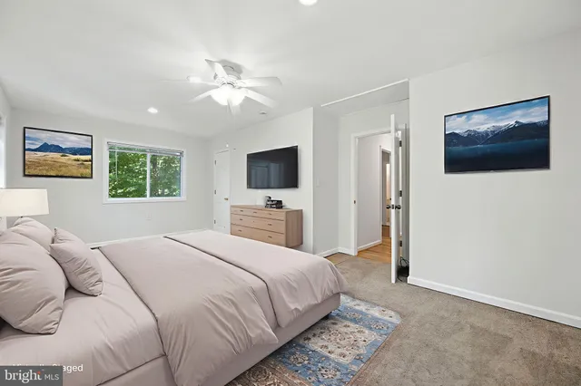 a bedroom with a large bed and a flat screen tv