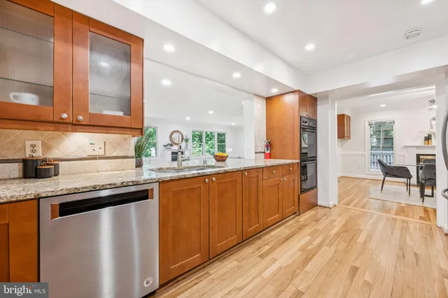 a kitchen with stainless steel appliances granite countertop a sink and wooden cabinets