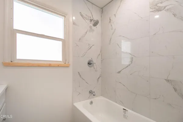 a bathroom with a bathtub and a shower