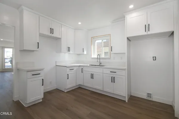 a kitchen with white cabinets appliances and a sink