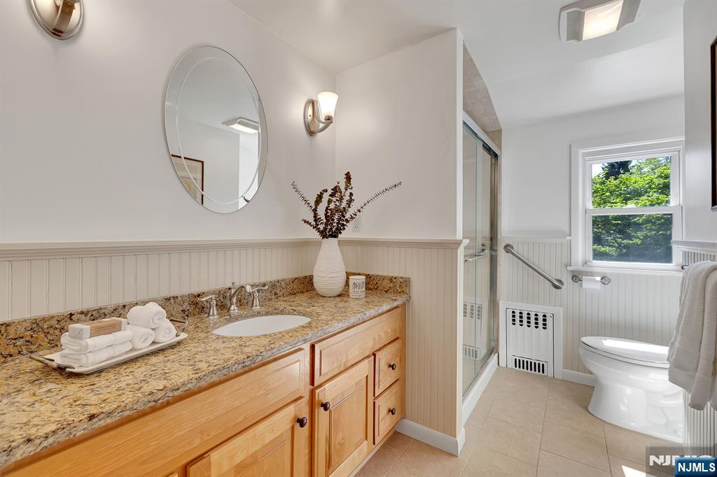 287 Jackson Avenue Rutherford, NJ 07070 - Photo 21 of 36 a bathroom with a granite countertop sink and a mirror