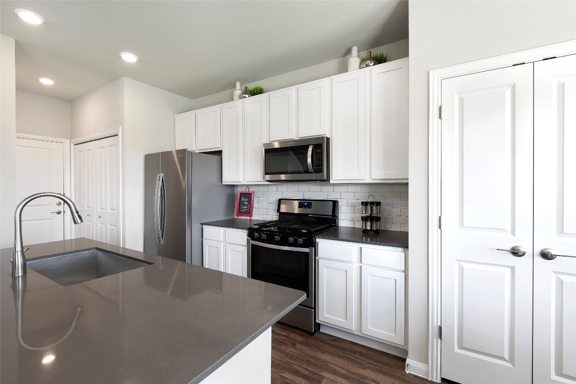 104 Arches Way Georgetown, TX 78626 - Photo 3 of 10 a kitchen with stainless steel appliances a refrigerator a sink a stove a microwave and cabinets