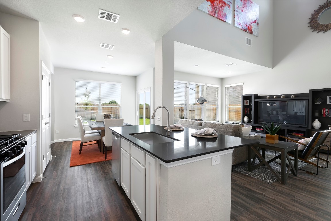 104 Arches Way Georgetown, TX 78626 - Photo 10 of 10 a kitchen with stainless steel appliances granite countertop a stove top oven a sink dishwasher a dining table and chairs with wooden floor