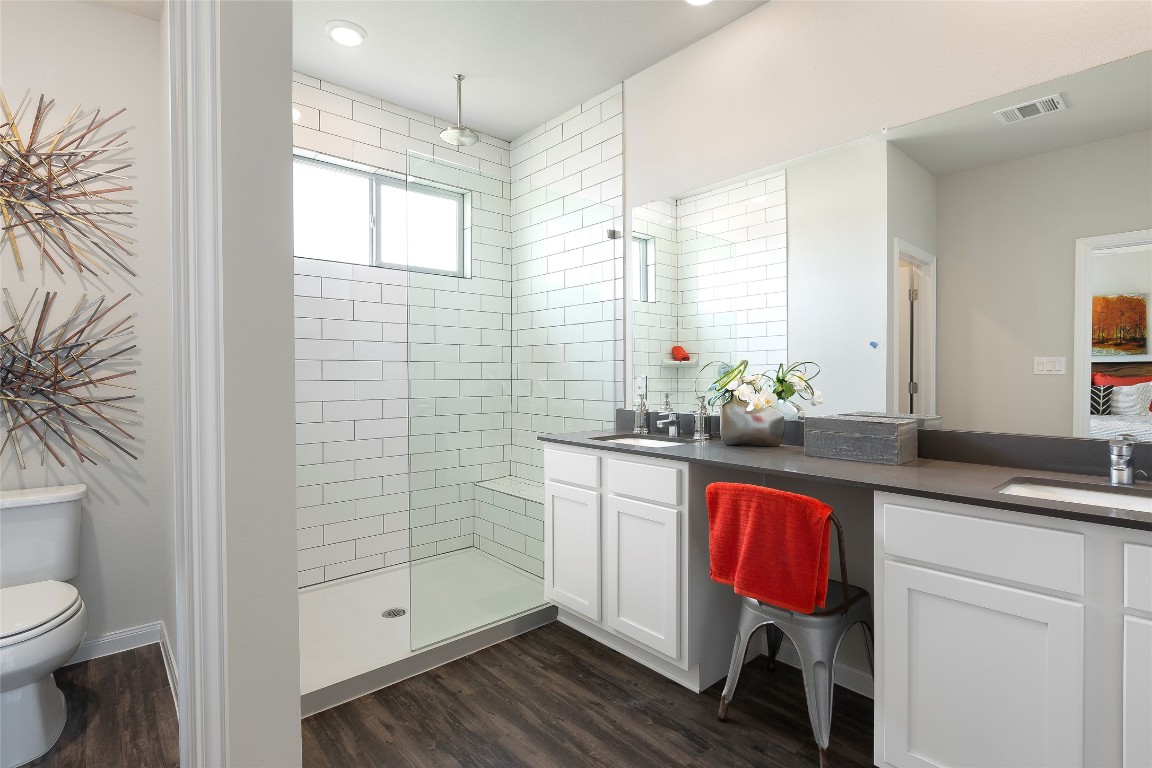 104 Arches Way Georgetown, TX 78626 - Photo 6 of 10 a spacious bathroom with a granite countertop sink a toilet a mirror and shower