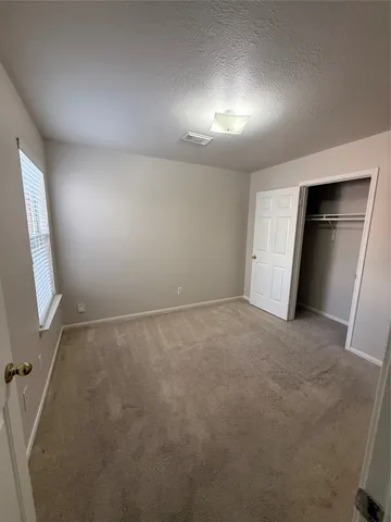 an empty room with closet and mirror