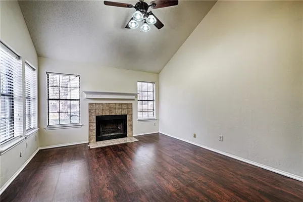 wooden floor fireplace and windows in an empty room