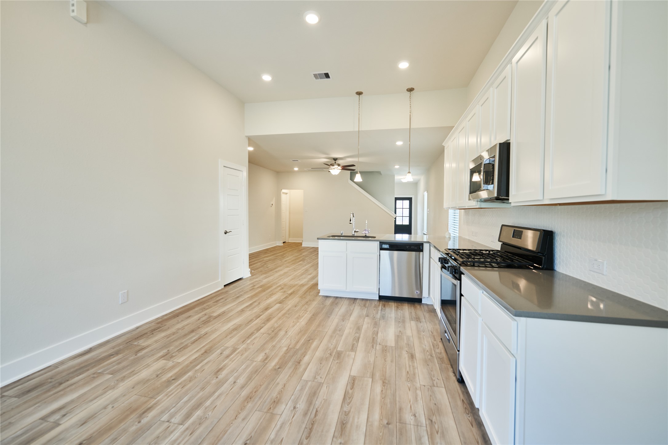10647 Whitejacket Conroe, TX 77385 - Photo 15 of 38 a kitchen with a sink a stove top oven and wooden floor