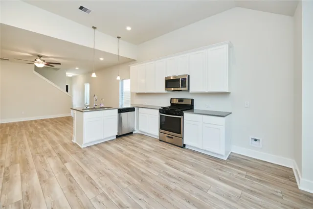 a view of kitchen with sink microwave and stove top oven