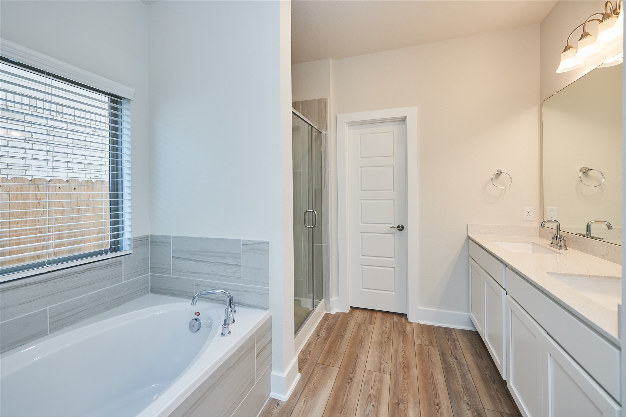 10647 Whitejacket Conroe, TX 77385 - Photo 20 of 38 a bathroom with a tub a sink and a large mirror
