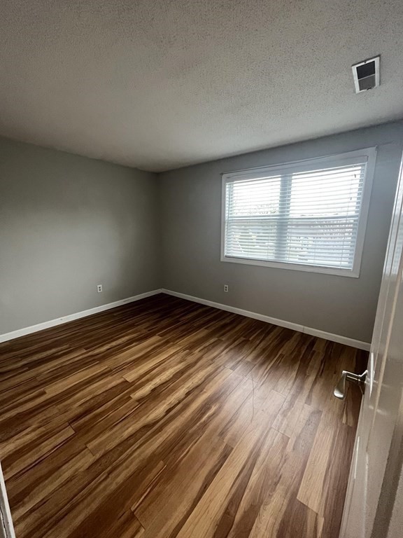 1475 Braley Road, Unit 21 New Bedford, MA 02745 - Photo 17 of 18 an empty room with wooden floor and windows