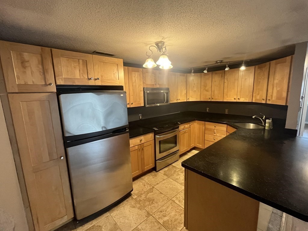 1475 Braley Road, Unit 21 New Bedford, MA 02745 - Photo 6 of 18 a view of a kitchen with a refrigerator and windows