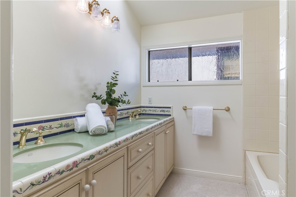 6090 Appian Way Long Beach, CA 90803 - Photo 22 of 41 a bathroom with a granite countertop sink and a mirror
