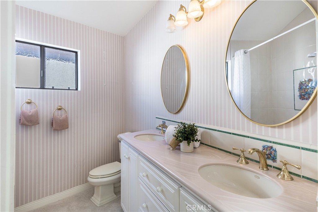 6090 Appian Way Long Beach, CA 90803 - Photo 25 of 41 a bathroom with a toilet a sink and mirror