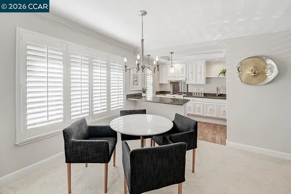 a dining room with kitchen island granite countertop furniture a large window and kitchen view