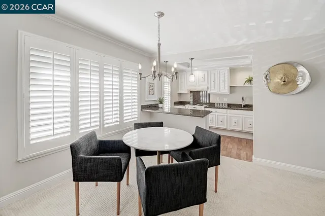 a dining room with kitchen island granite countertop furniture a large window and kitchen view