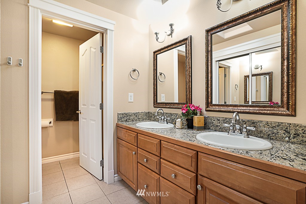 2806 183rd Avenue Northeast Redmond, WA 98052 - Photo 19 of 40 a bathroom with a granite countertop sink mirror and a shower