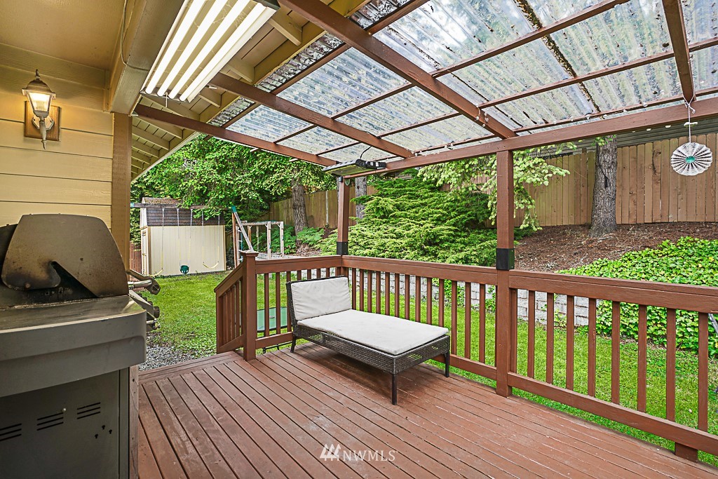 2806 183rd Avenue Northeast Redmond, WA 98052 - Photo 31 of 40 a view of a patio with table and chairs under an umbrella with a small yard