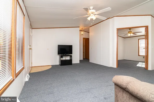 a view of livingroom with furniture chandelier fan and windows