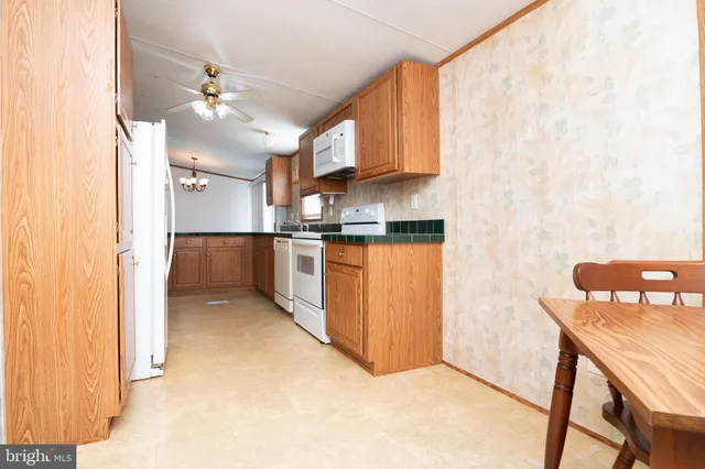 a view of a kitchen with kitchen island stainless steel appliances wooden floor and view living room