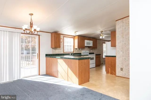 a view of a kitchen with kitchen island a sink wooden floor and a counter top space
