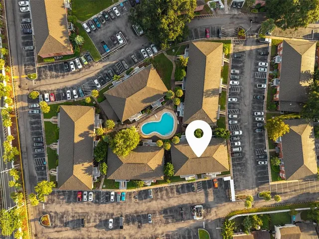 an aerial view of a swimming pool with outdoor seating