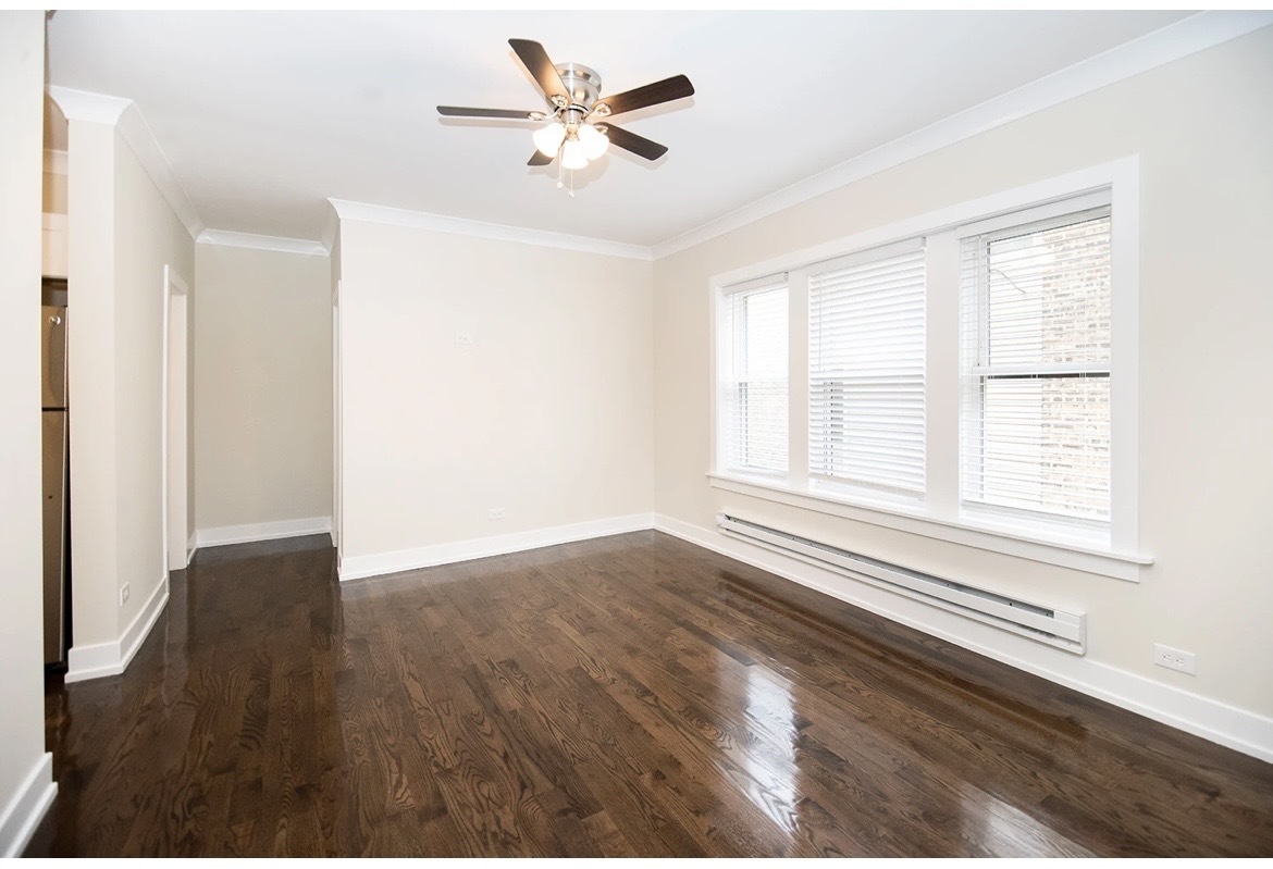 648 West Roscoe Street, Unit 2N Chicago, IL 60657 - Photo 7 of 12 an empty room with wooden floor and windows