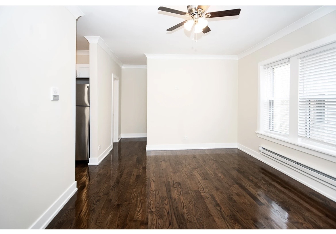 648 West Roscoe Street, Unit 2N Chicago, IL 60657 - Photo 8 of 12 a view of an empty room with wooden floor and a window