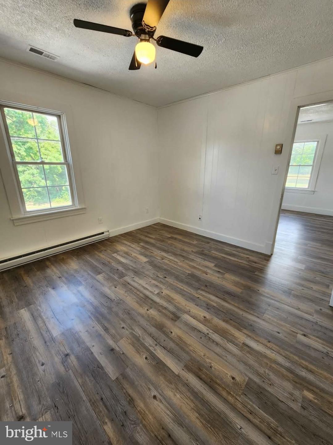 26530 Three Notch Road, Unit 1 Mechanicsville, MD 20659 - Photo 3 of 9 an empty room with wooden floor fan and windows