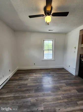 a view of empty room with wooden floor and window