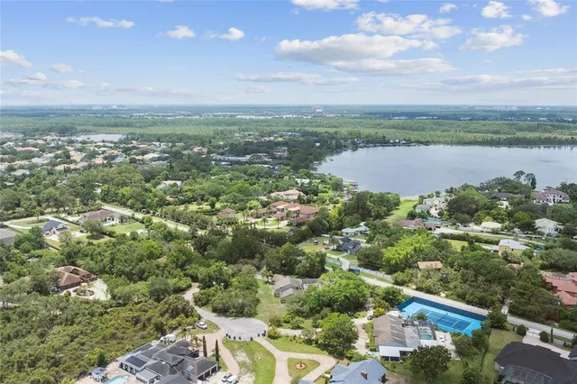 an aerial view of residential houses with outdoor space and trees