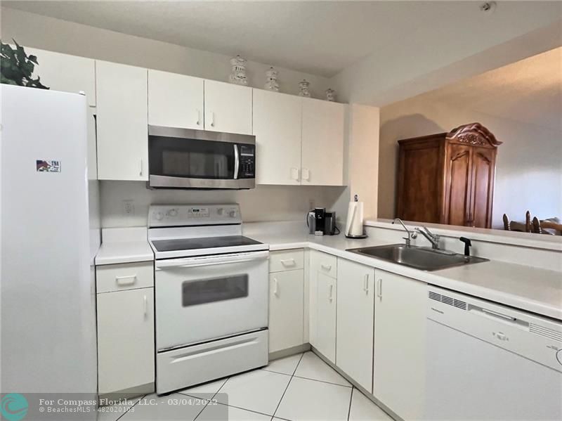 9537 Weldon Circle, Unit I308 Tamarac, FL 33321 - Photo 4 of 12 a kitchen with appliances a sink and cabinets