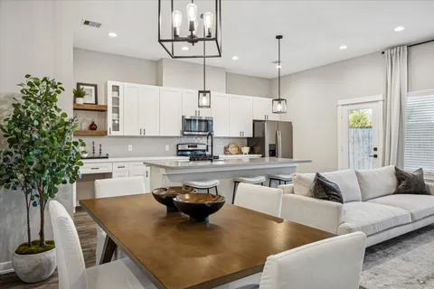a living room with kitchen island furniture and a potted plant