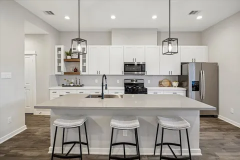 a kitchen with refrigerator a sink and chairs