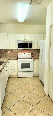 a kitchen with a stove top oven and cabinets