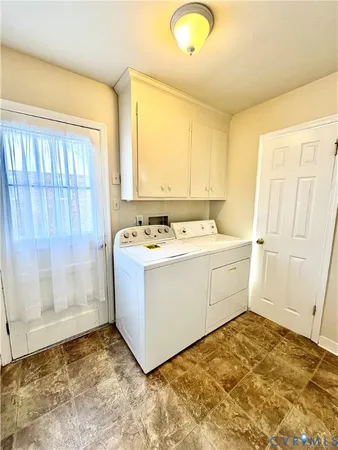 a utility room with cabinets washer and dryer