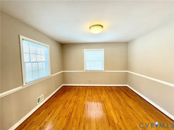 a view of a room with wooden floor and windows