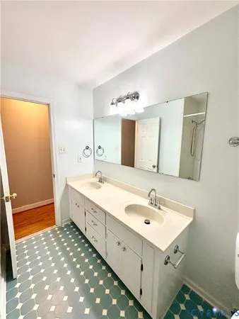 a spacious bathroom with a double vanity sink and a mirror