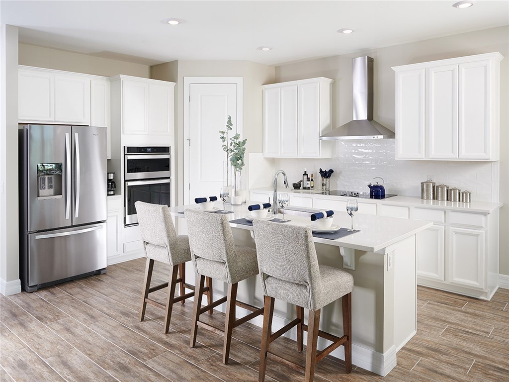 a kitchen with stainless steel appliances a white table and chairs in it