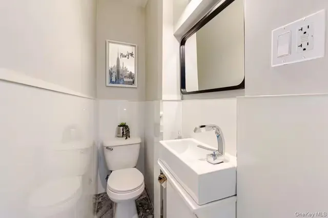 a bathroom with a toilet a sink and mirror