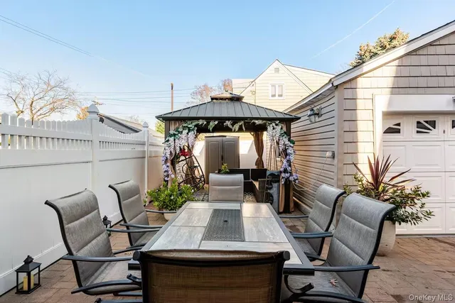 a view of a patio with table and chairs with wooden floor and fence