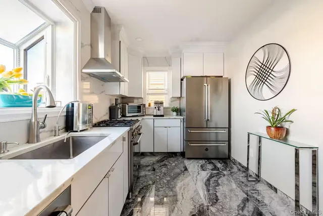 a kitchen with a refrigerator a stove a sink and a window