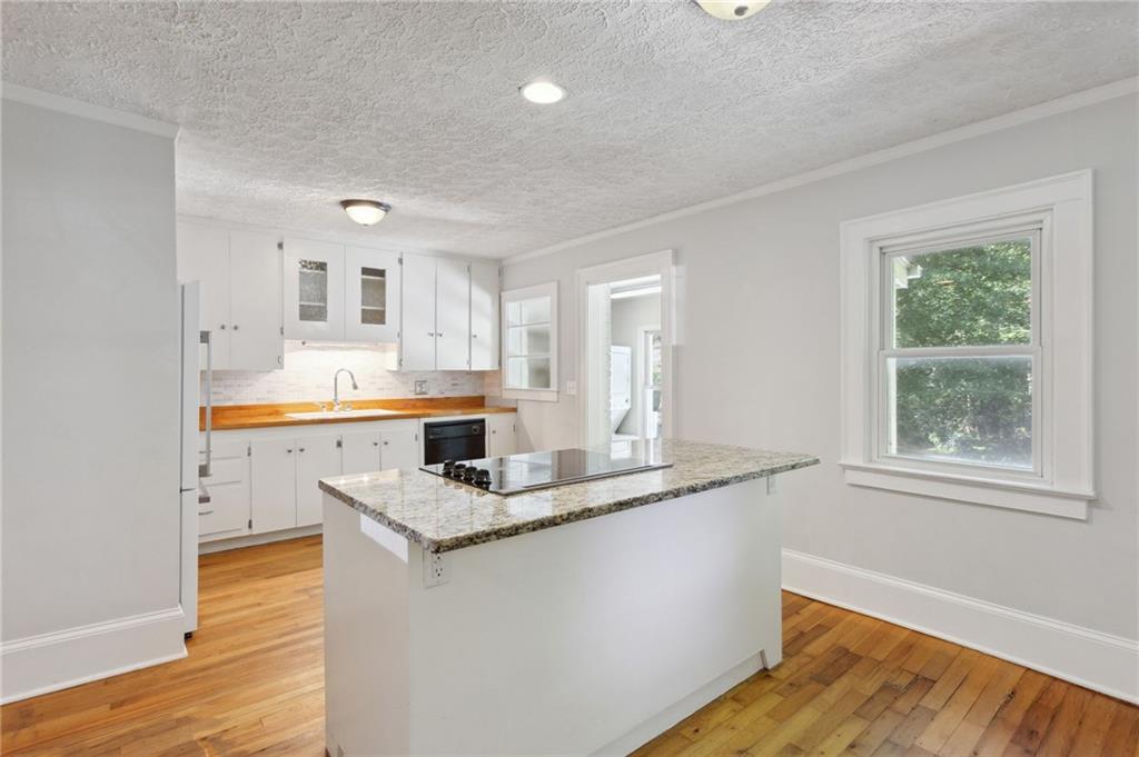 385 Sunset Drive Athens, GA 30606 - Photo 15 of 48 a kitchen with stainless steel appliances granite countertop a sink stove and wooden floor