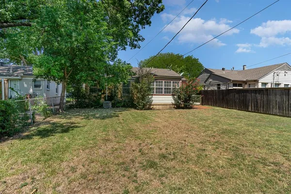 a view of a house with backyard and a tree