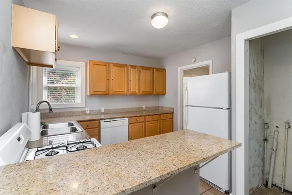 a kitchen with a refrigerator stove top oven and sink