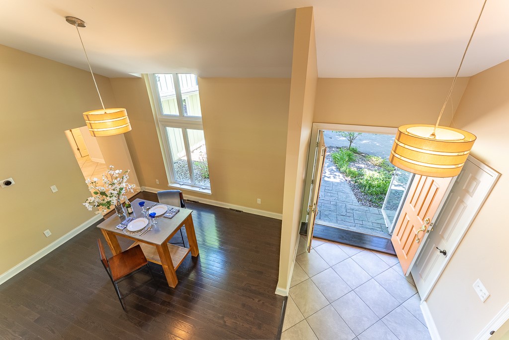 220 Hibiscus Drive Rochester, NY 14618 - Photo 4 of 50 Inside, a breathtaking dining room rises to meet you, bathed in natural light from a soaring two-story window.