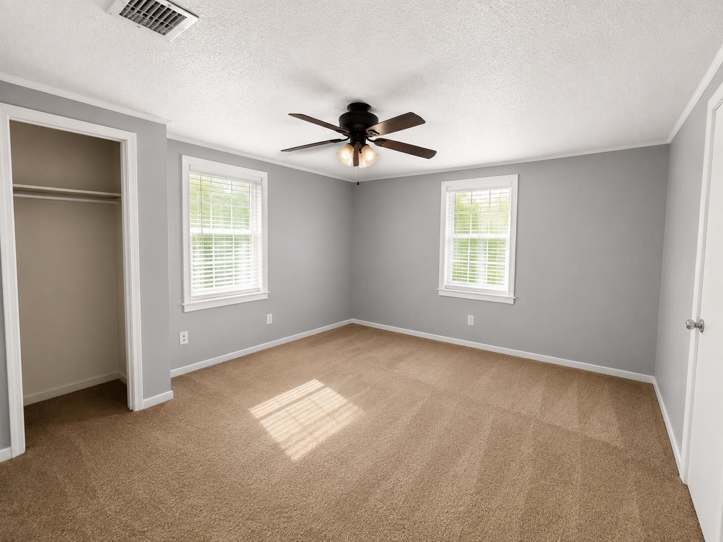 7503 Walsh Road Millington, TN 38053 - Photo 5 of 27 Neutral gray walls, brown carpet, ceiling fan with integrated lighting, two windows with blinds, and an open closet